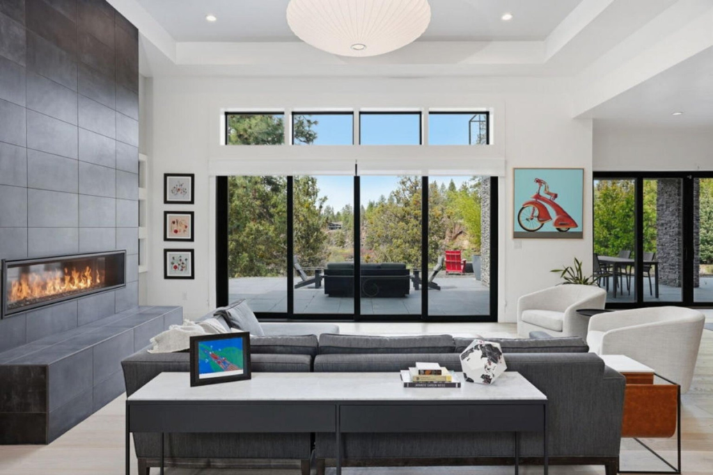 Light-filled living room with modern fireplace and expansive windows connecting the interior to the Central Oregon landscape