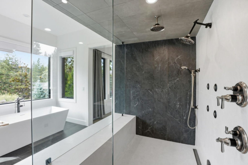 Contemporary glass-enclosed shower and soaking tub in a modern Central Oregon home